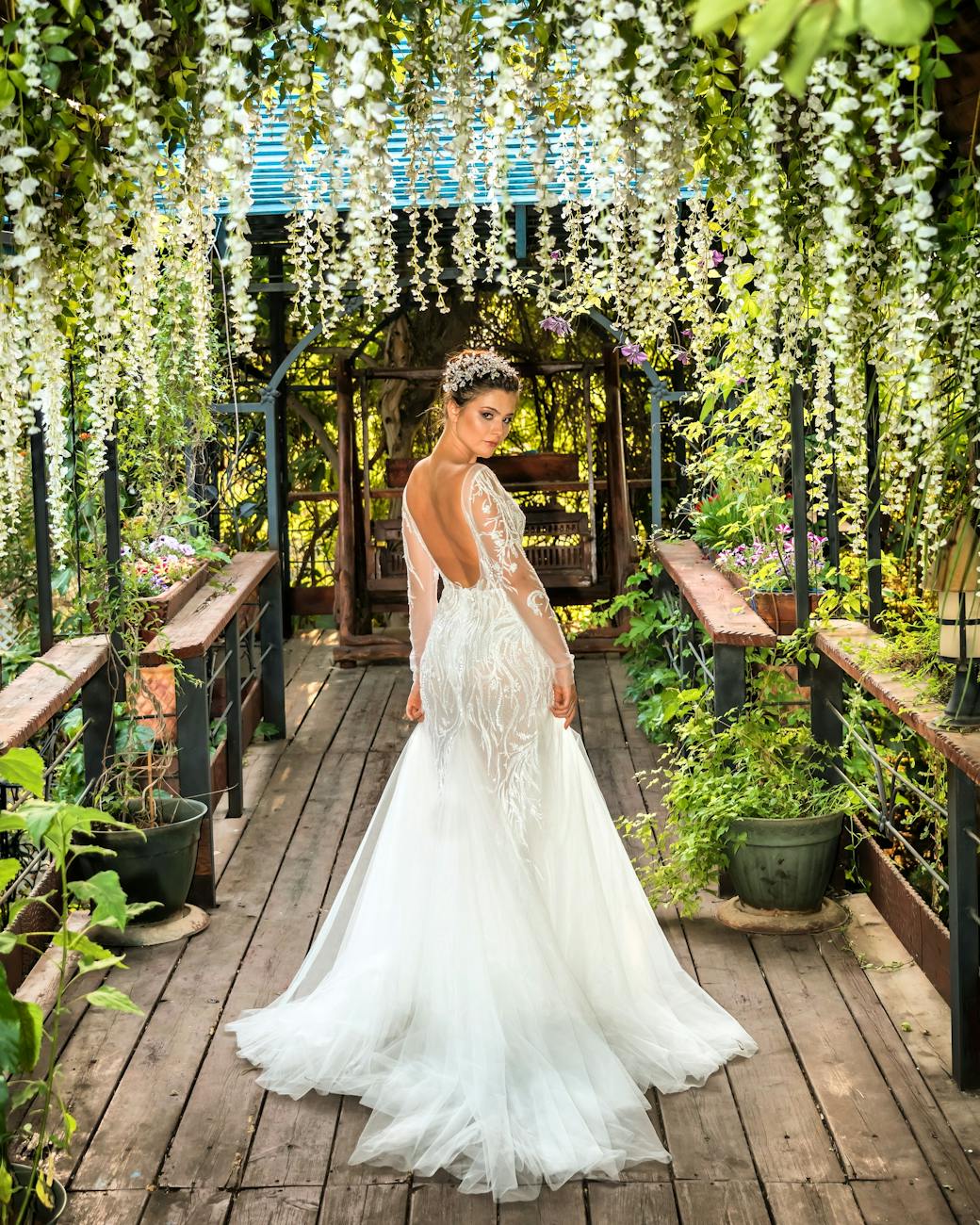 Bride in a stunning white bridal gown posing in a lush garden archway