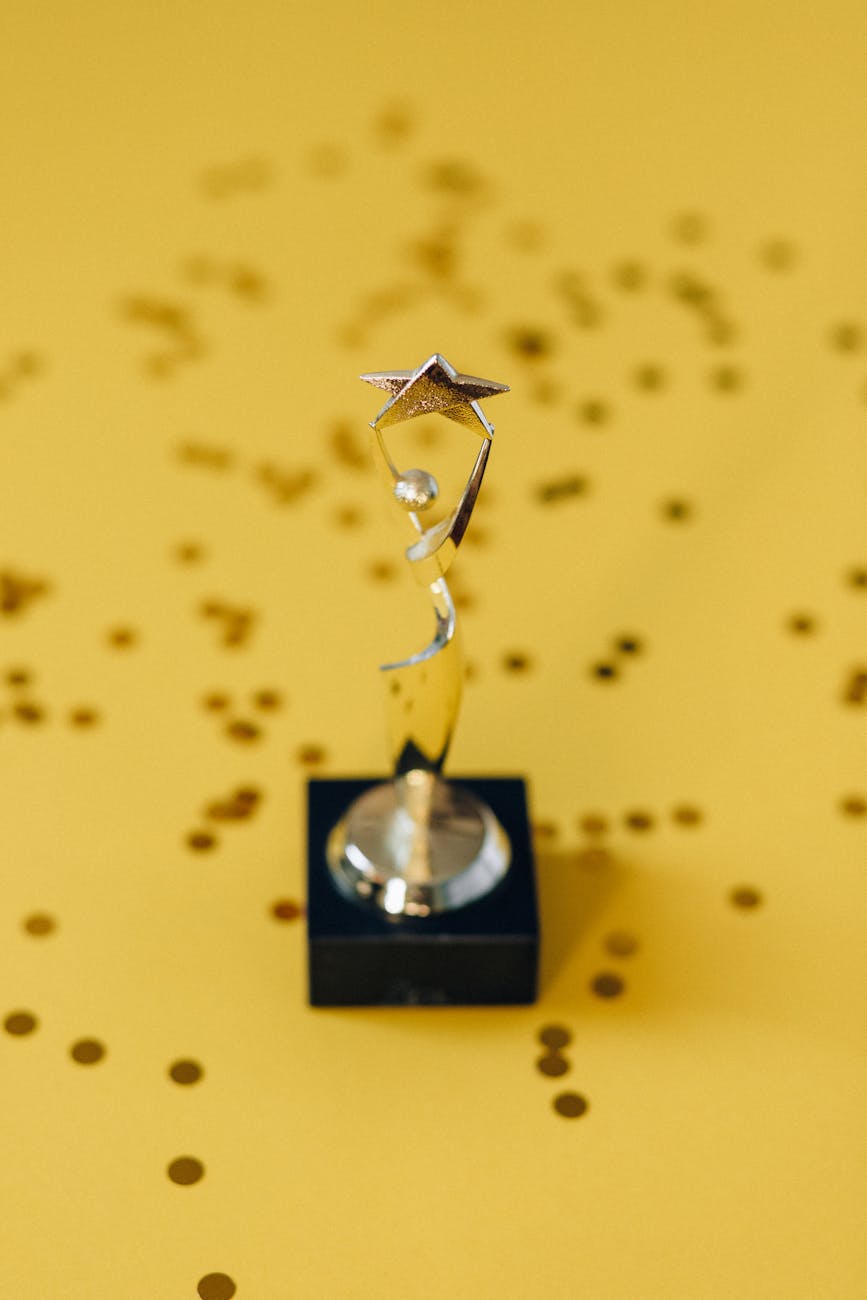 Silver star trophy on yellow background with confetti. Perfect for success concepts.