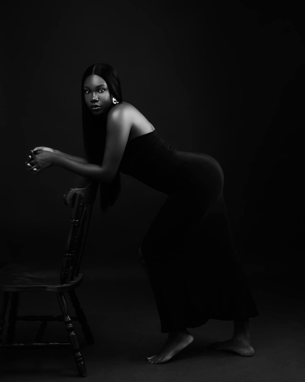 Stunning black and white portrait of a woman in a graceful pose, showcasing elegance.