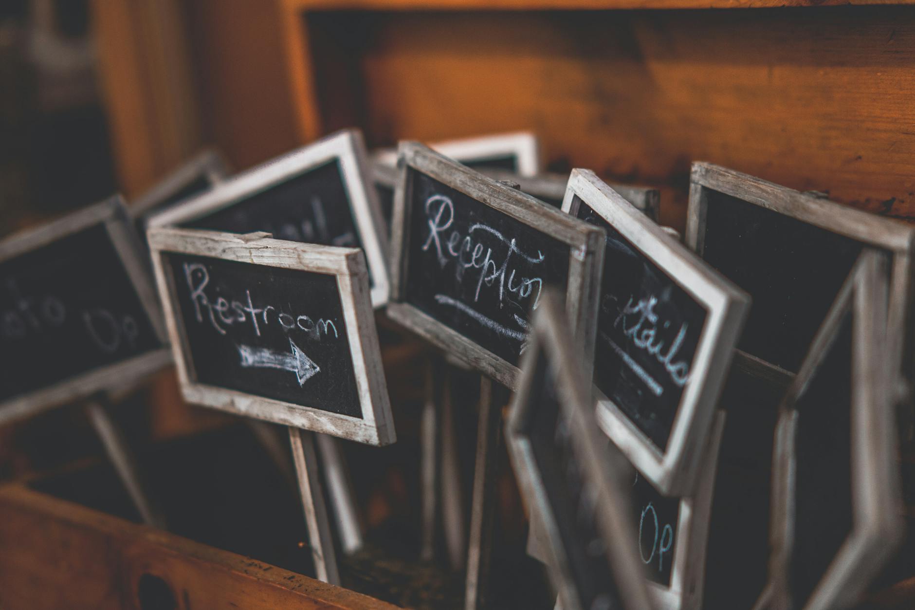 Rustic collection of small chalkboard signs used for event directions and labeling.